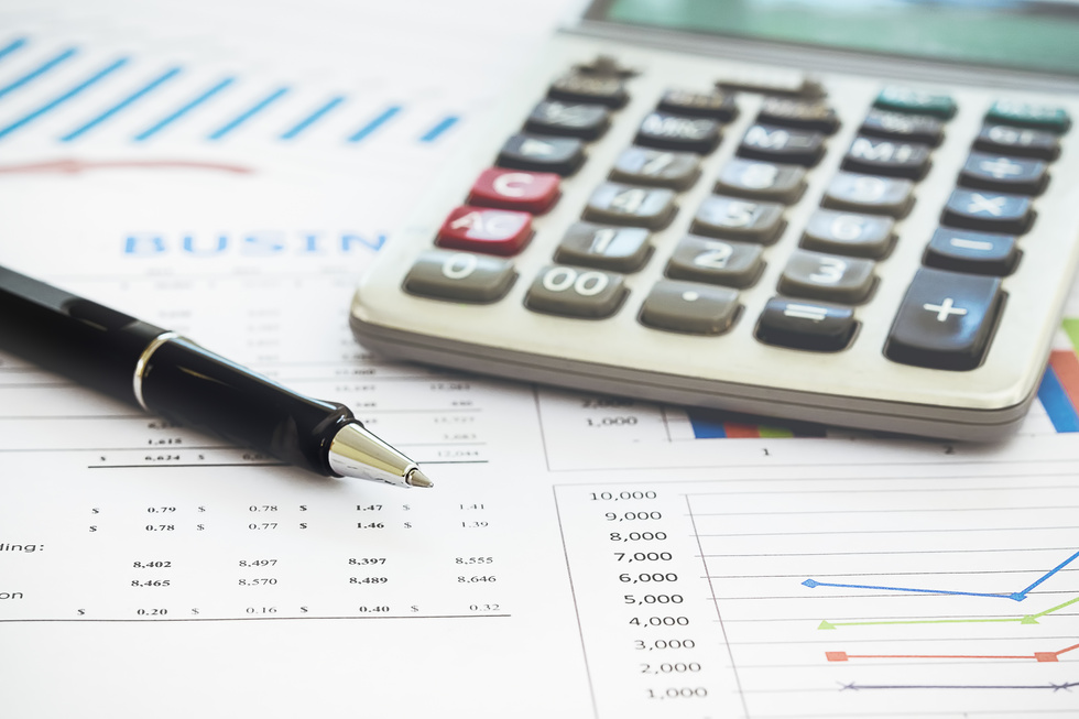 Close Up of Graphs and Calculator with Pen